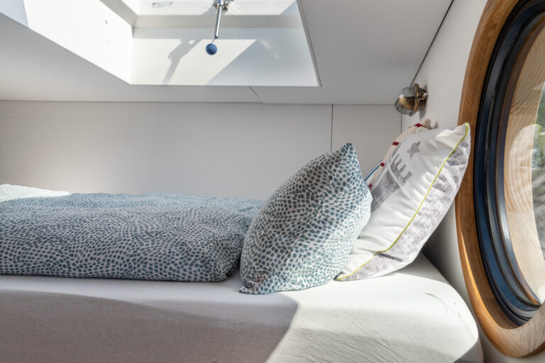 Das Bett auf der höher gelegenen Schlafebene ist 1,60 m breit. Durch ein Dachfenster schweift der Blick in den Himmel.