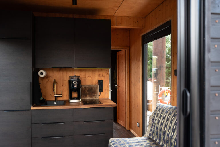 Der kleine Wohn-Küchenbereich auf dem Hausboot: gut ausgestattete Küchenzeile, (Schlaf)Sofa, Holzofen, Ausblicke.