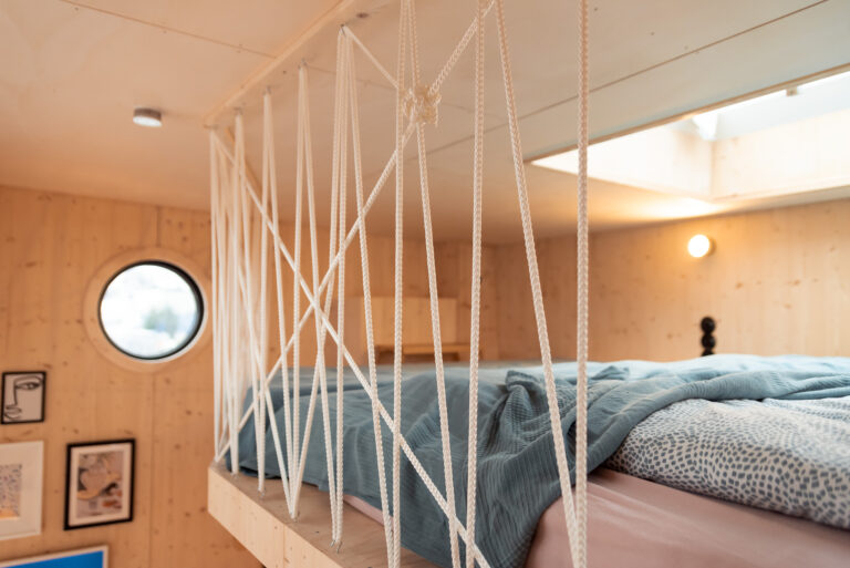 Große höher gelegene Schlafebene auf dem Hausboot OFF mit breitem, gemütlichem Bett.