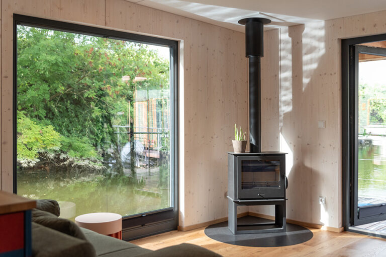 Kamin und großes Außenfenster auf dem Hausboot Villa Kunterbunt